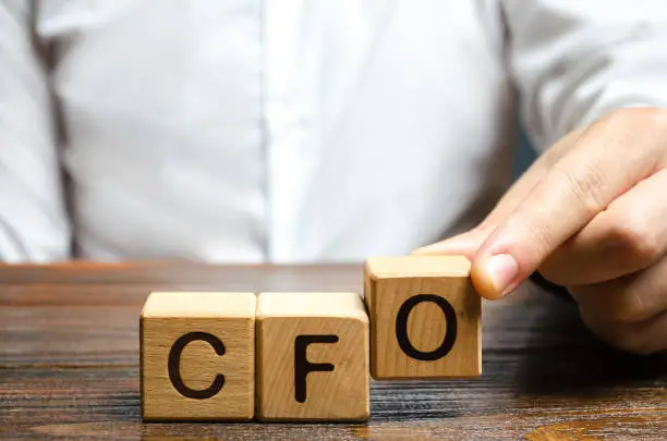 Photo of A man makes the word acronym abbreviation CFO. Chief Financial Officer. Financial management in business and company. Risk. Development and growth. Appointment to a new post, promotion.