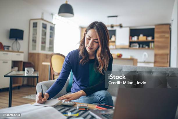 Young Japanese Woman Doing Her Finances At Home Stock Photo - Download Image Now - Tax Form, Tax, Home Finances