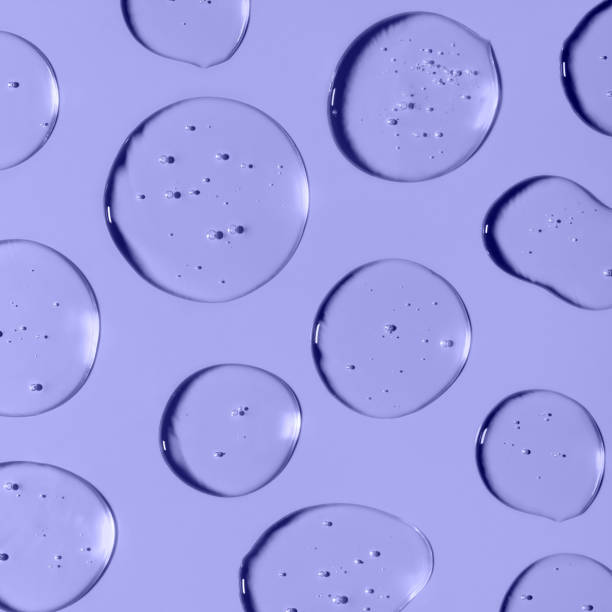 Transparent Gel drops forming background or pattern. Gel drops on light purple background. Virus protection cosmetics concept. Square composition. Trendy banner with 2022 color of the year very peri