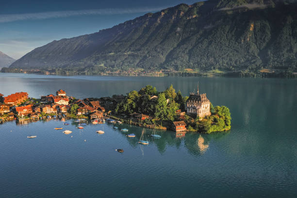 日の出の青い湖の典型的なスイスの村 - brienz house switzerland european alps ストックフォトと画像