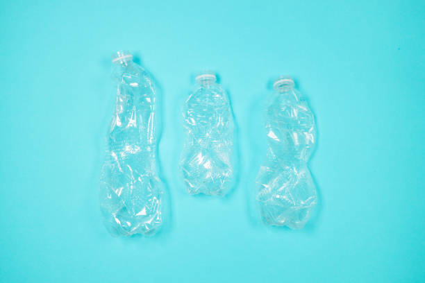 istock Many many used empty PET bottles on a blue background, top view. Recycling problem 1358281789