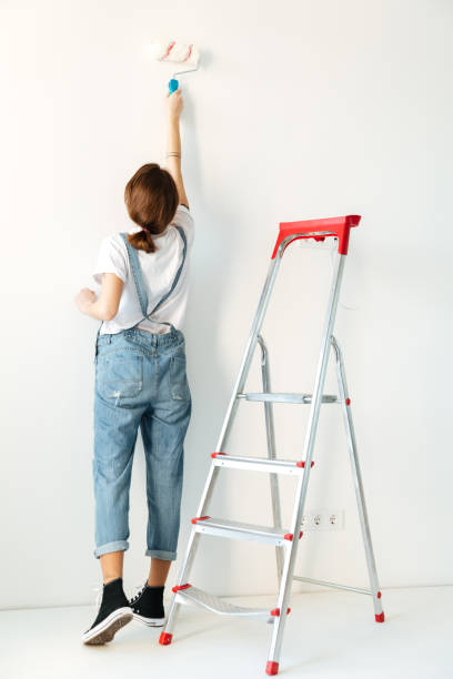 istock Back view image of lady in new flat make repair. 1358282396