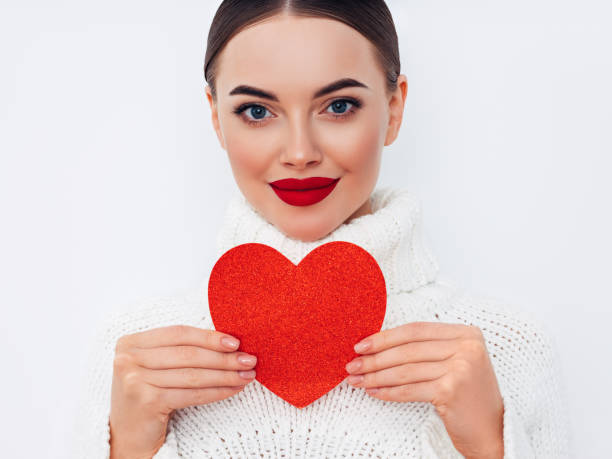 istock Beautiful young woman holding an artificial heart 1358282507