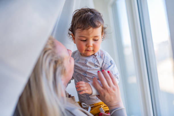 istock Mother playing whit her baby boy by the window 1358283761