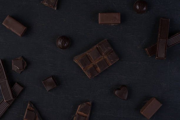 istock Top view of cracked dark chocolate bar with sweets 1358283827