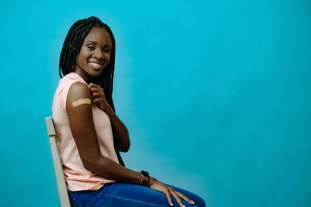 istock Vaccinated attractive young woman smiling with plaster on hand right after getting covid-19 vaccine shot 1358285682