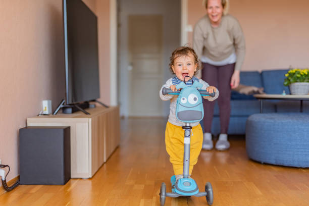 istock Boy driving push scooter with his mother 1358285703