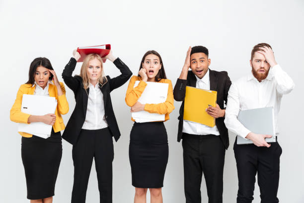 istock Shocked group of colleagues standing isolated in office. 1358287133