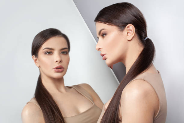 istock Sad thinking woman and self-image mirror on white background. Stress, depression and doubt, psychology concept 1358288360