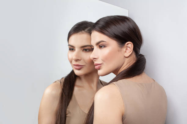 istock Pretty smiling woman with mirror on white background 1358288362
