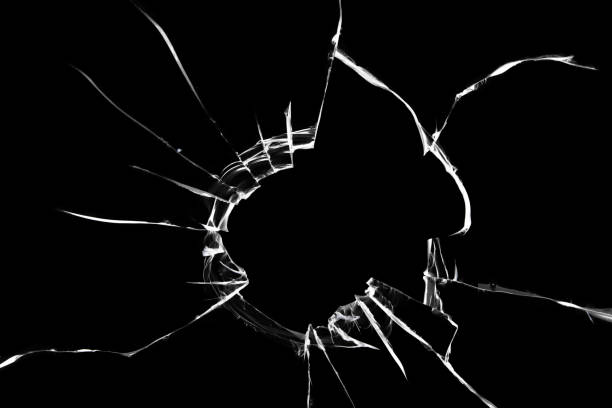 istock Texture of cracks on the glass. A hole in a broken window. 1358289298