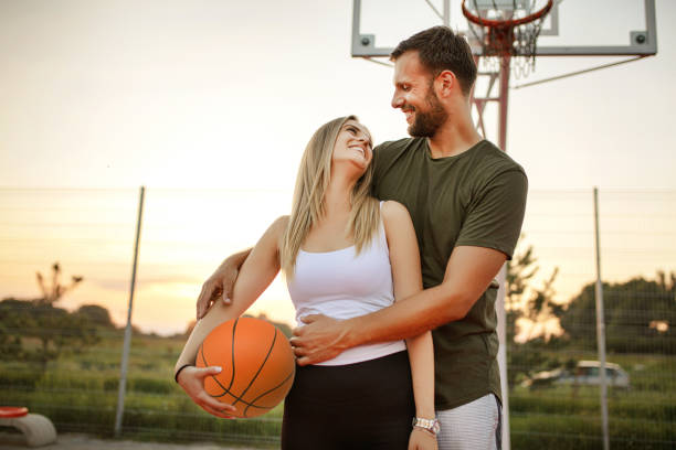 istock Young happy couple having a wonderful time while playing basketball 1358295071
