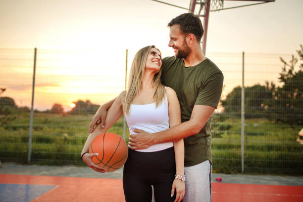 istock Young happy couple having a wonderful time while playing basketball 1358295124