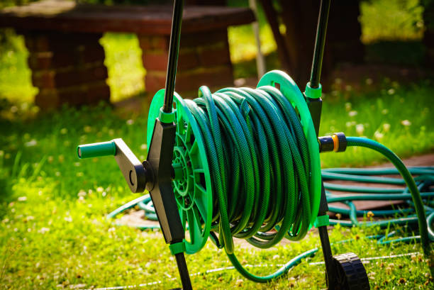istock Garden hose for watering plants in garden 1358296733