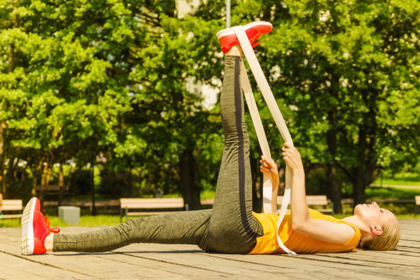 istock Girl doing exercises outdoor, using fit band. 1358297453