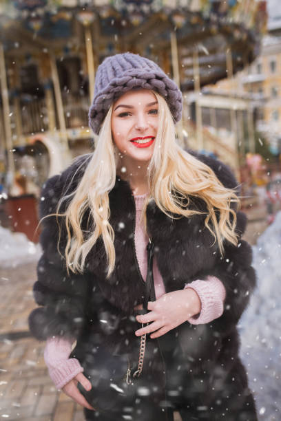 istock Cheerful lady enjoying holiday fair in snowfall 1358297628