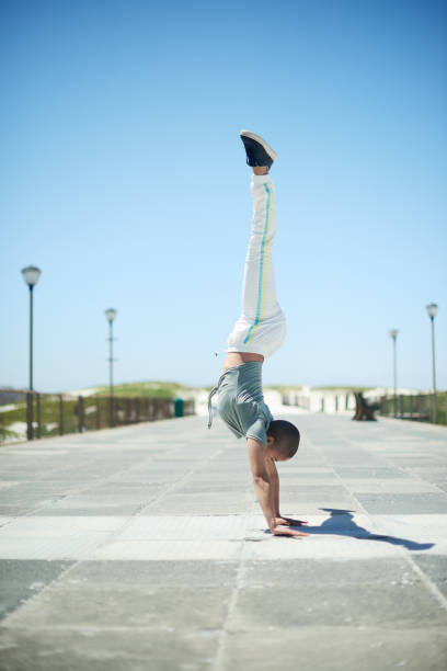 istock Shot of a young woman doing a handstand while dancing outside 1358299995