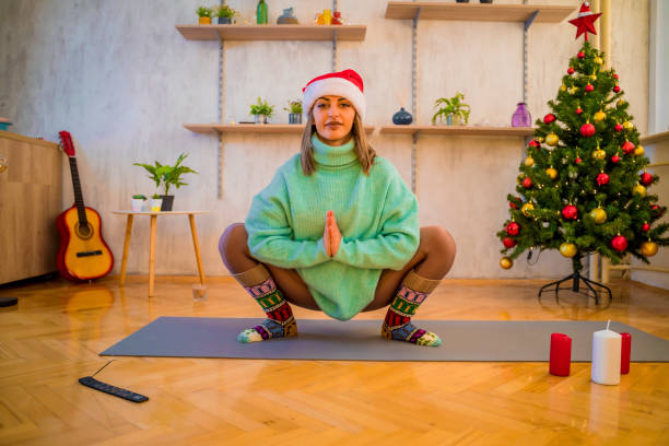 istock Woman near Christmas tree doing yoga 1358305591
