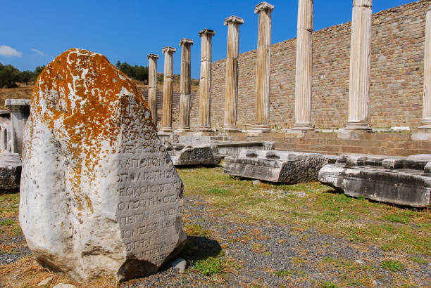 pergame, turquie. pierre avec inscriptions grecques, colonnes ioniques et mur de pierre à asklepieion - temples de guérison de la grèce antique. - bergama photos et images de collection