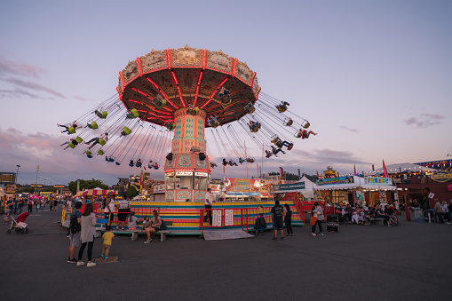 Puyallup, USA - Aug 31, 2019: People enjoying the rides at the Washington State Fair at sunset. The Fair is known by locals as the Puyallup fair and has been running since 1900.