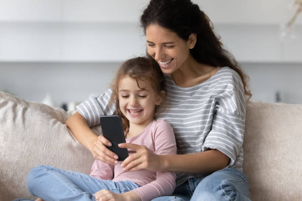 istock Happy mother and small daughter using cellphone apps. 1358310806