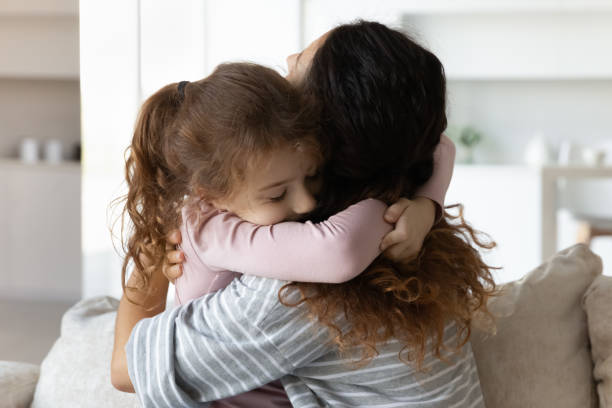 istock Loving small child girl cuddling affectionate mother. 1358310819