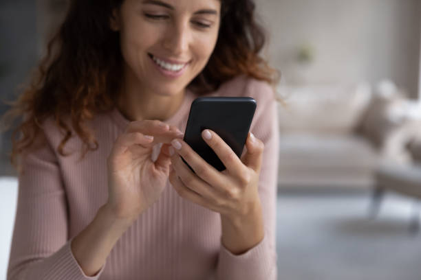 istock Smiling millennial latin woman using cellphone software applications. 1358310858