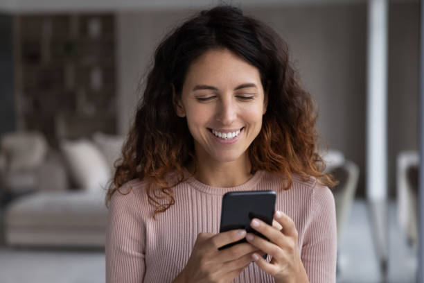 istock Smiling young hispanic woman reading pleasant message on cellphone. 1358310875