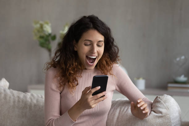 istock Overjoyed young woman celebrating online lottery win. 1358310882