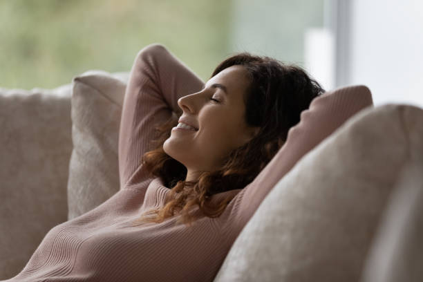istock Smiling relaxed hispanic woman sleeping on sofa. 1358310884