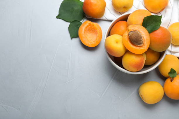 istock Many fresh ripe apricots on light grey table, flat lay. Space for text 1358319265