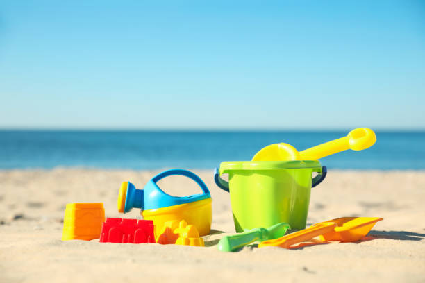 istock Different child plastic toys on sandy beach. Space for text 1358319337