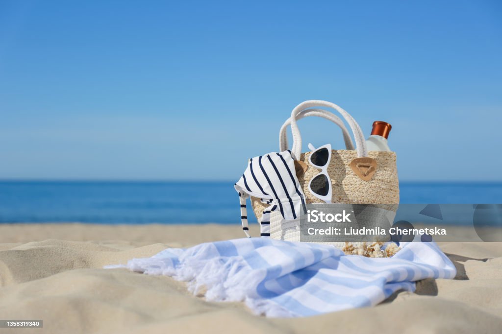 Stylish beach accessories for summer vacation on sand near sea. Space for text Swimwear Stock Photo