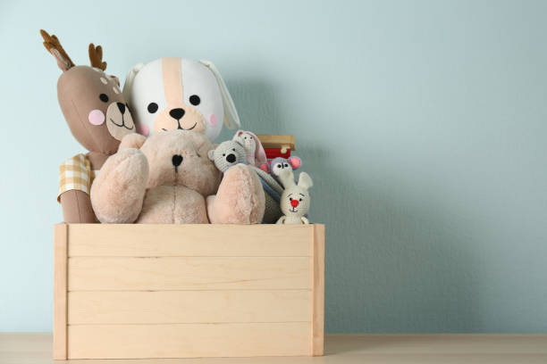 istock Crate with different toys on wooden table. Space for text 1358320255