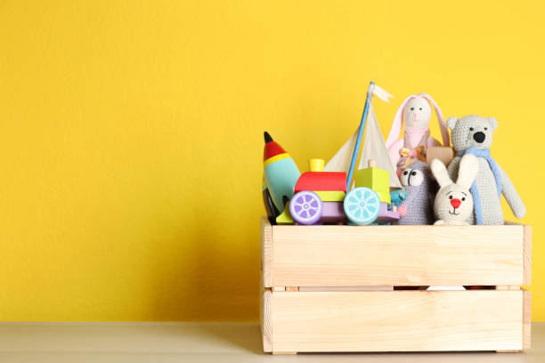 istock Crate with different toys on wooden table. Space for text 1358320622