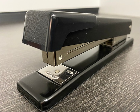 Close up image of a black office staple sitting on a desk by itself