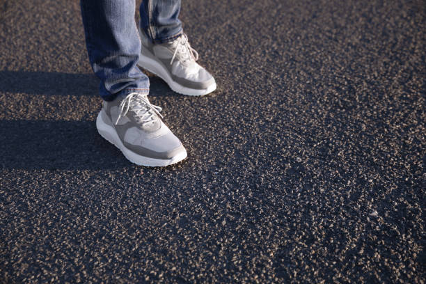 istock Man standing on road, closeup with space for text. Choosing way concept 1358322494