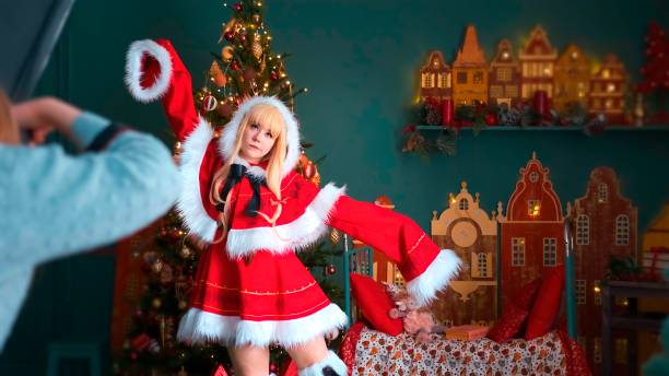 linda chica con un disfraz rojo del elfo de año nuevo. posando para el fotógrafo. tema de año nuevo - cosplay de anime fotografías e imágenes de stock