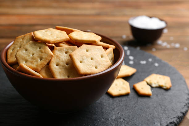 istock Delicious crispy crackers on wooden table, closeup 1358325876