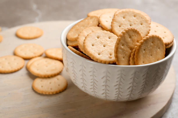 istock Delicious crispy crackers on wooden board, closeup 1358326009