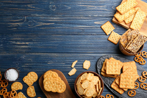 istock Many delicious crackers on blue wooden table, flat lay. Space for text 1358326388