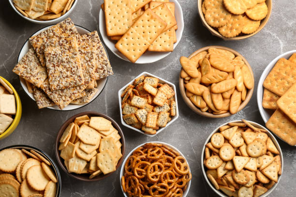 Different delicious crackers in bowls on grey table, flat lay Different delicious crackers in bowls on grey table, flat lay SALTINE CRACKER stock pictures, royalty-free photos & images