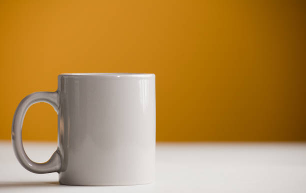 istock light gray cup of coffee on the table, with yellow background 1358328696
