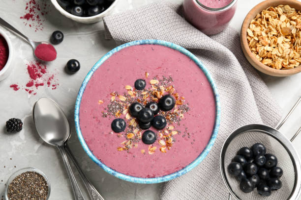 istock Delicious acai smoothie with granola and chia seeds served on grey table, flat lay 1358328708