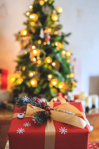 istock beautiful gift on a bokeh background with a Christmas tree. Copy space 1358329725
