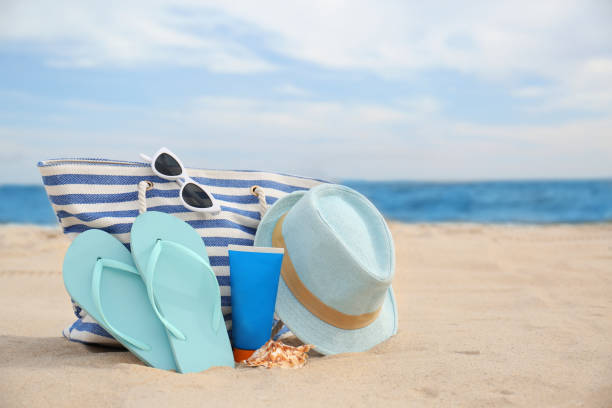 istock Different stylish beach objects on sand near sea 1358330445