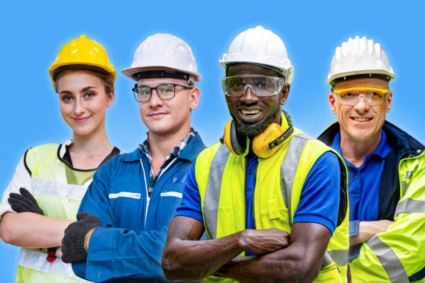 istock group workers engineering standing with confident with blue working suite dress and helmet in front of blue background. Concept of smart industry worker operating. Diversity of people of industry. 1358333998