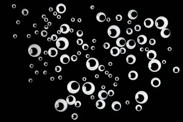 Photo of Many googly eyes on black