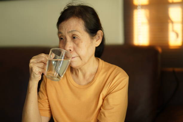 istock Senior asian woman drinking water. 1358342582