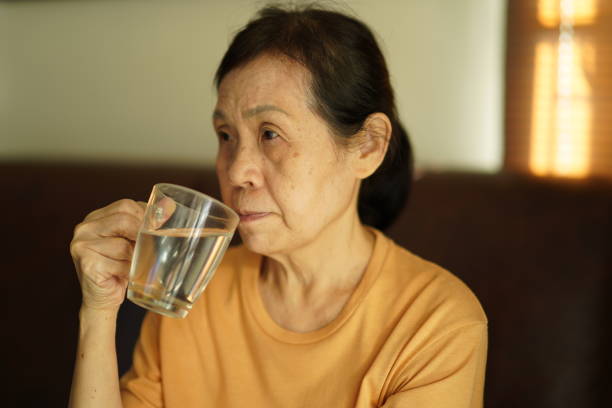 istock Senior asian woman drinking water. 1358342588